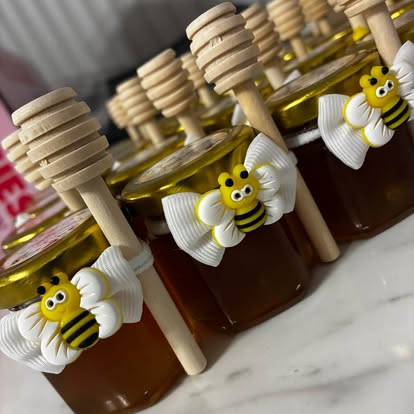 Mini honey jars with bee ribbons and wooden dippers